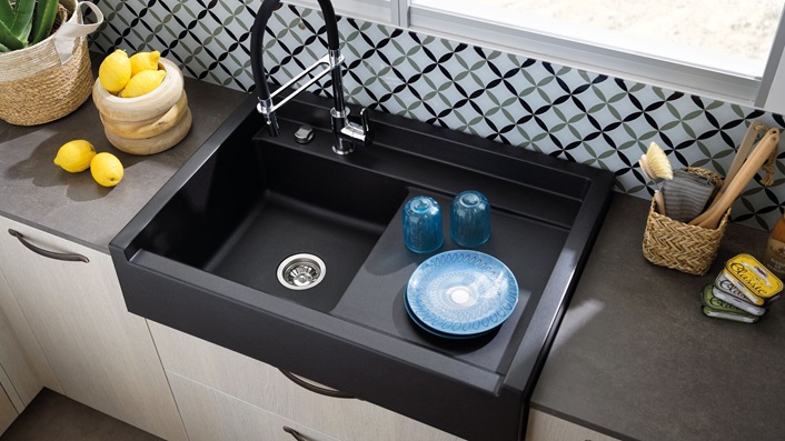 évier timbre d’office noir avec mitigeur douchette, plan de travail gris, façade couleur bois et crédence en verre