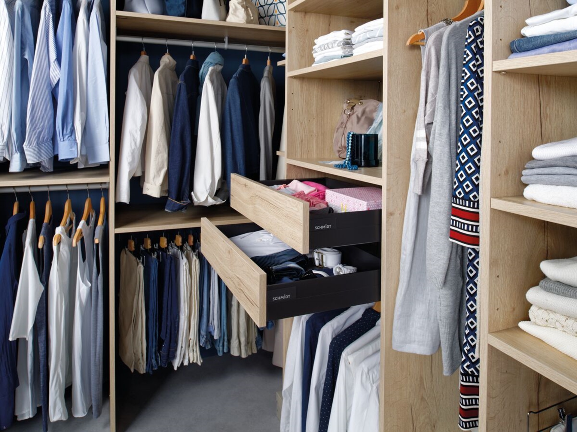 Vue globale du dressing Arcos melaminé en coloris bois, avec les penderies, les placards et les tiroirs remplis