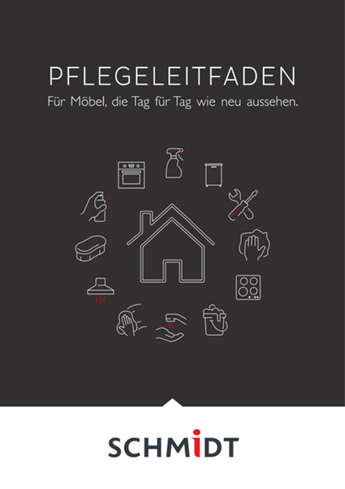 Vue d'un salon avec un canapé et une table basse, une cheminée avec un feu allumé au premier plan et les baies vitrées en arrière plan.