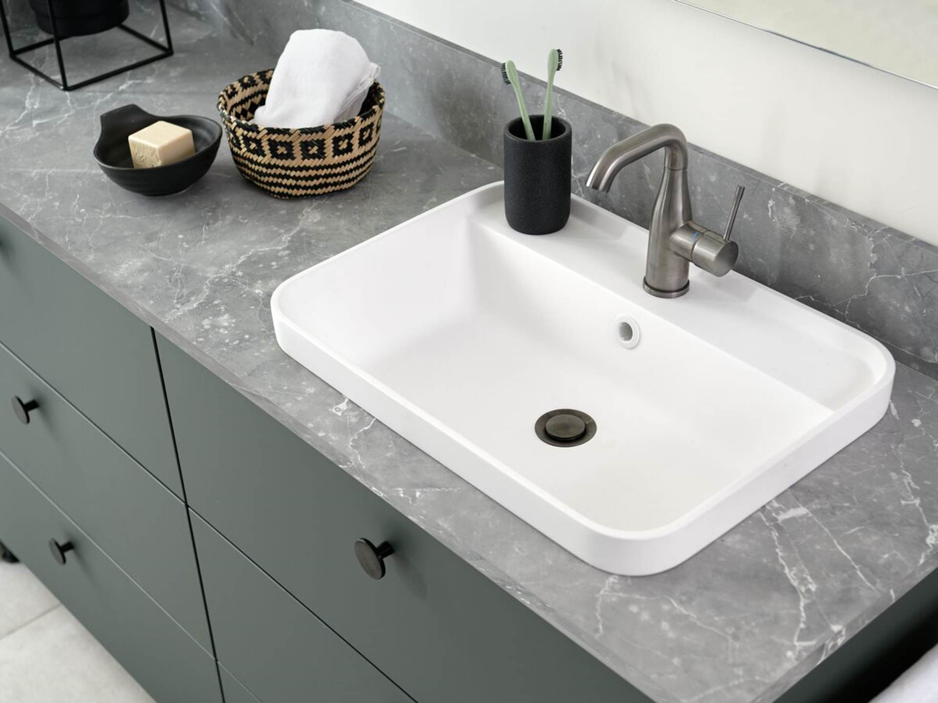 Lavabo arrondi et plan de travail gris aspect pierre