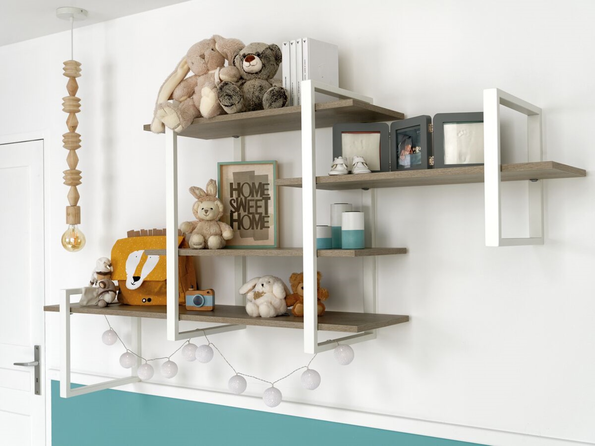 Vue du meuble souspendu de la chambre bébé, avec des peluches posés dessus