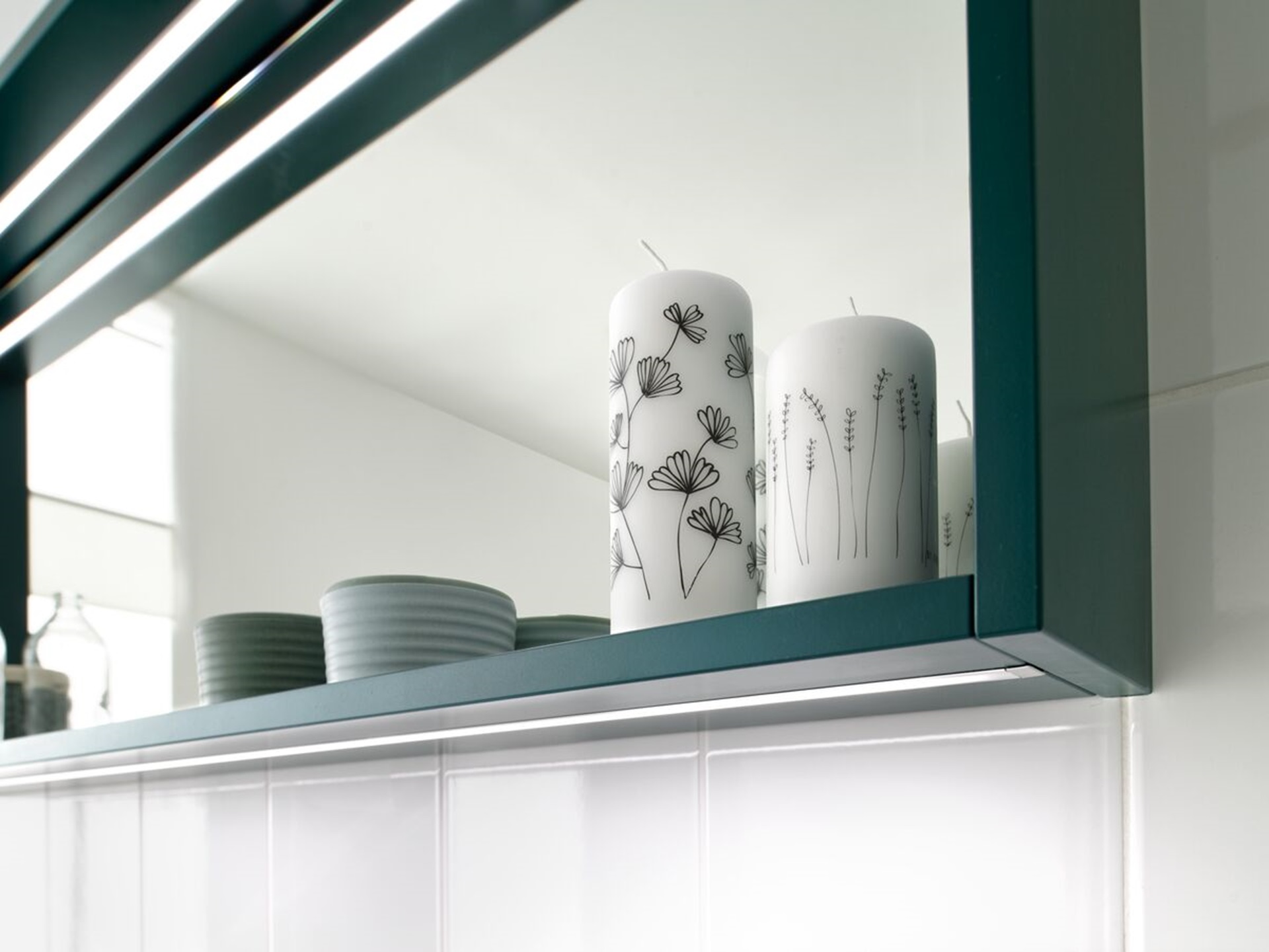 Zoom sur la décoration posée sur le cadre décoratif vert émeraude du miroir sur mesure rectangulaire.